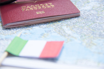 Adventure concept. Sunglasses, small Italy flag and passport on map