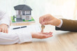 © petzshadow - Businessman or sale man giving a house key to woman - .buying home concept  with fair