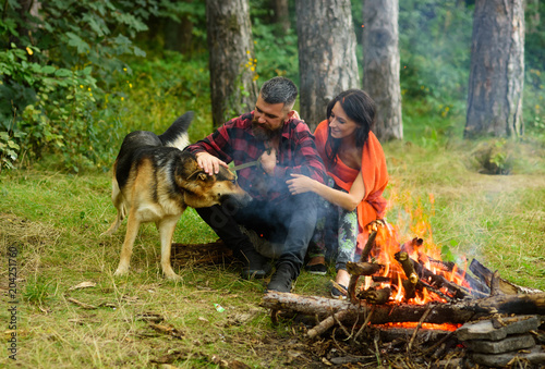 Fotografering Couple play with german shepherd dog near bonfire,