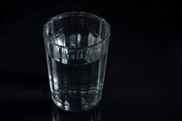 Wall Mural - A glass with water on a dark background