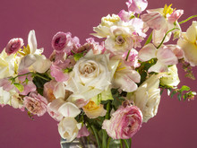 Close-up Of Rose Flowers In Vase On Pink Background