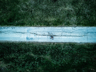 aerial view of alone man walking in the dark moody forest road