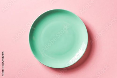 Fotografía Green plate on pink background, from above