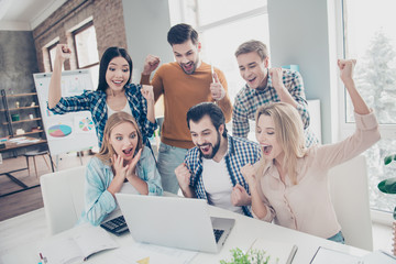 Wall Mural - Attractive stylish confident cheerful positive beautiful handsome lucky economists looking at screen of laptop with wondered, glad emotions raised hands open mouth yelling full of happiness