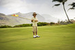 © Erickson Stock - A boy holding a golf flag on the golf course