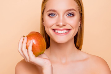 Wall Mural - Clear strong white straight teeth stomatology concept. Cropped close up portrait of attractive charming nude natural model having red apple in hand isolated on beige background