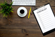 Blank checklist with space for ticks on pad on office desk. Checklist for office worker, manager, businessman, chief on dark wooden background top view copy space