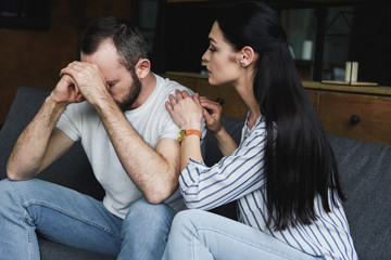 Wall Mural - young wife asking forgiveness from husband after quarrel at home