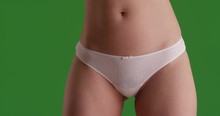 Close up of lovely young woman in white panties on greenscreen studio backdrop