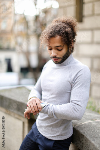 Black Male Person With Curly Hair Looking At Watch And