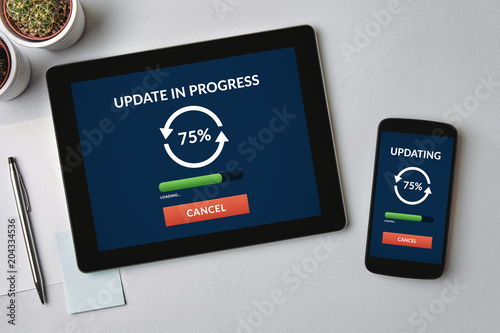 Fotografía Update concept on tablet and smartphone screen over gray table