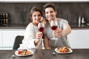 Wall Mural - Portrait of a happy young couple holding glasses