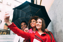 Group Of Three Beautiful Young Multiracial Women Having Fun Walking On The Rain