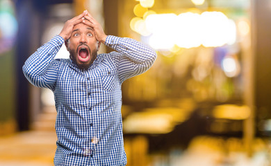 Poster - African american man with beard stressful keeping hands on head, terrified in panic, shouting at night