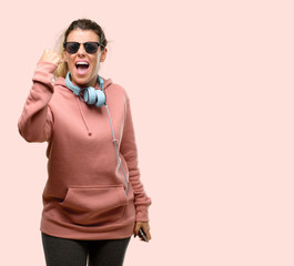 Canvas Print - Young sport woman with headphones and sunglasses covering ears ignoring annoying loud noise, plugs ears to avoid hearing sound. Noisy music is a problem.