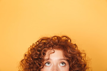 Wall Mural - half face of young woman looking up at copy space