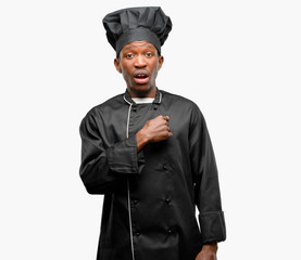 Poster - Young black cook wearing chef hat happy and surprised cheering expressing wow gesture, pointing with finger