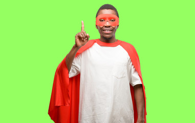 Poster - African black super hero man happy and surprised cheering expressing wow gesture pointing up