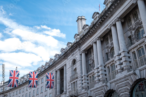 Fotomural Close up of buildings on Regent Street London UK photographed from street level, with row of British flags to celebrate the Royal Wedding of Prince Harry to Meghan Markle