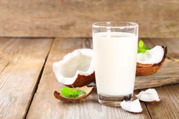 Wall Mural - Coconut and coconut milk in glass, mint on wooden old table.