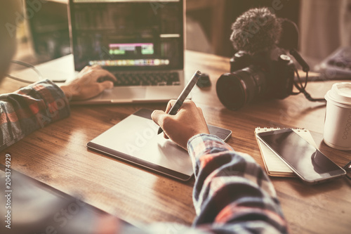 Fotomural Youtuber editing video on laptop for up to worldwide through an online freelance work