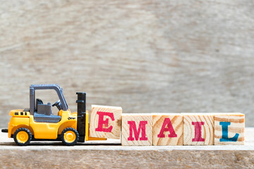 Poster - Toy forklift hold letter block E to complete word email on wood background