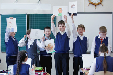 Wall Mural - Pupils at the lesson hand over their drawings for examination