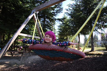 Little girl swinging on a swing on a playground