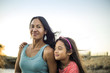 © Erickson Stock - Smiling mother and daughter standing outdoors