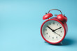 © samrit - Red vintage alarm clock on light blue color background