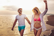 © Mediteraneo - Romantic couple having fun on the beach. Happy couple running on beach at sunset.