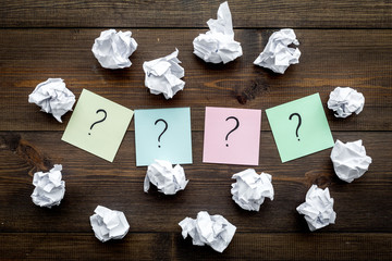 Poster - FAQ concept. Question mark on sticky notes near crumpled paper on dark wooden background top view