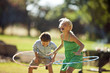 © Erickson Stock - Happy siblings playing with hula hoops in their back yard.