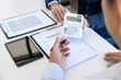 © Freedomz - Businessman being analysis and making the decision a car insurance policy, Agent man is holding the calculator and waiting for his reply to finish