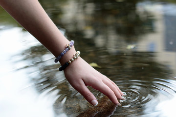 beautiful hand of a young girl touching the water 