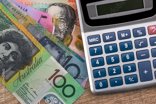 Australian Dollar Banknotes With Calculator On Wooden Table Australian Dollar Banknotes With Calculator On Wooden Table