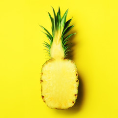 Wall Mural - half of sliced pineapple on yellow background. top view. copy space. bright pattern for minimal styl