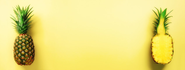 Wall Mural - half slice of fresh pineapple and whole fruit on yellow background. banner. top view. copy space. br