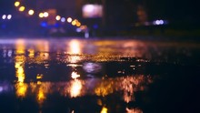 Cars Drive Into Large Puddles On The Night Road In The City, Spray Puddles Scatter From Under The Wheels Of The Car