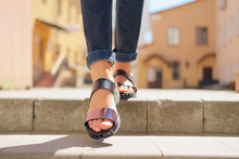 Female Legs In Sandals Descending The Stairs In The City