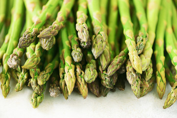 Wall Mural - Green fresh asparagus on gray background. Top view. Raw, vegan, vegetarian and clean eating concept.