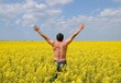 © eleonimages - Free man in the field. The man raised his hands up. Field of flowering rape.