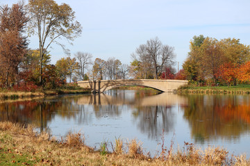 Wall Mural - autumn view in a city park. beautiful fall landscape with a bridge in the city park. colored trees a