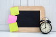 Chalkboard, Alarm clock and blank sticky note, post note on Office desk white wooden vintage background