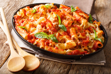 Casserole ziti pasta with minced meat, tomatoes, herbs and cheese close-up on a plate. horizontal