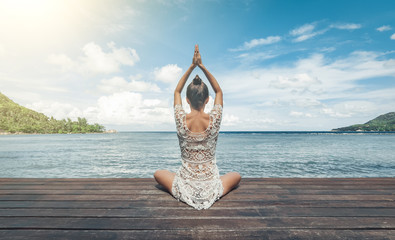 Young woman making meditation on the beach