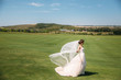 Beautiful bride in luxury fashion white wedding dress with veil on the green golf club glade, wedding day. Amazing full length body portrait of girl. Marriage concept.