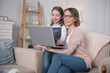 © Viacheslav Yakobchuk - My project. Pretty joyful mother sitting with her daughter and working on the laptop