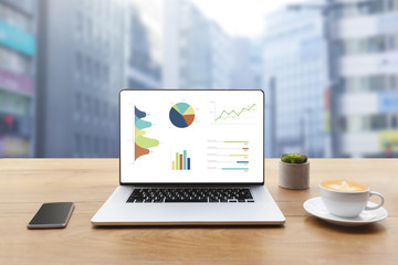 Aufkleber - Laptop on wooden table showing charts and graph