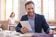 © Viacheslav Yakobchuk - Designer workplace. Joyful male designer smiling to camera while using tablet